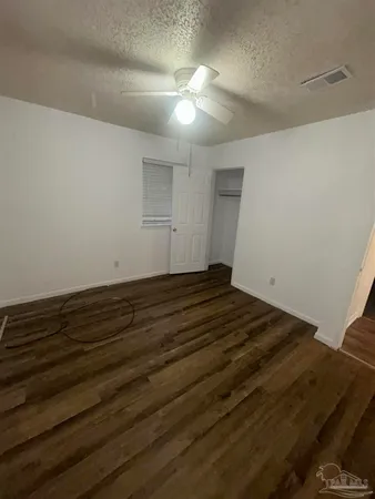 a view of a room with wooden floor and ceiling fan