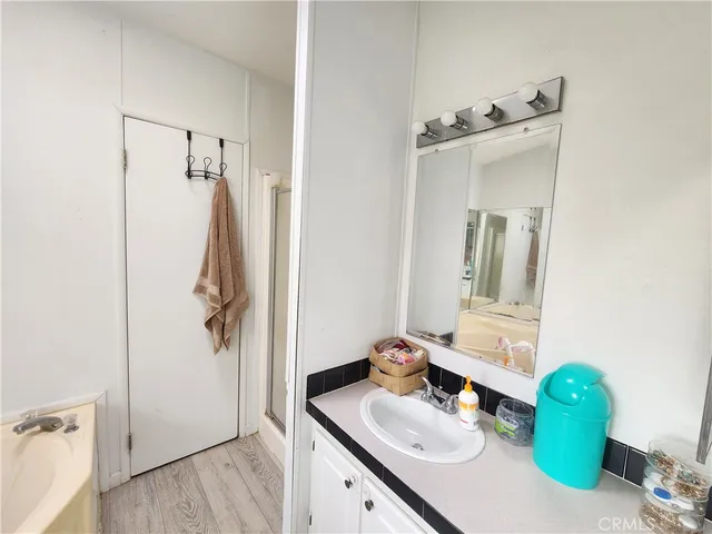 a bathroom with a sink vanity granite tub and shower