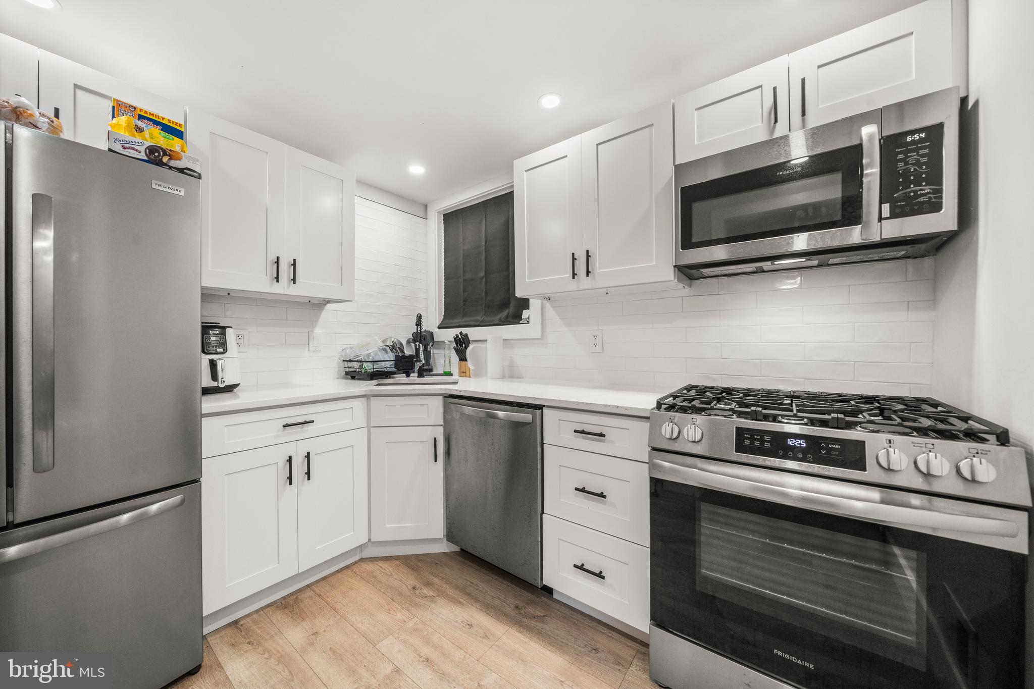3707 Dunlap Street Temple Hills, MD 20748 - Photo 9 of 30 a kitchen with stainless steel appliances white cabinets and a stove a oven with wooden floor