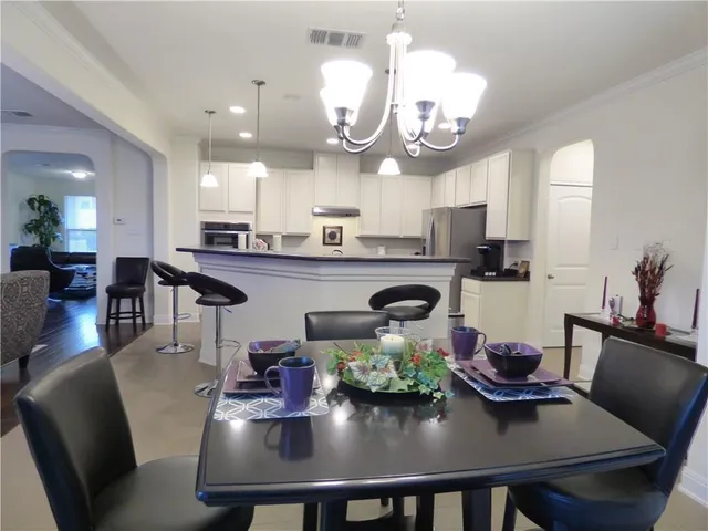 a kitchen with stainless steel appliances granite countertop a dining table and chairs