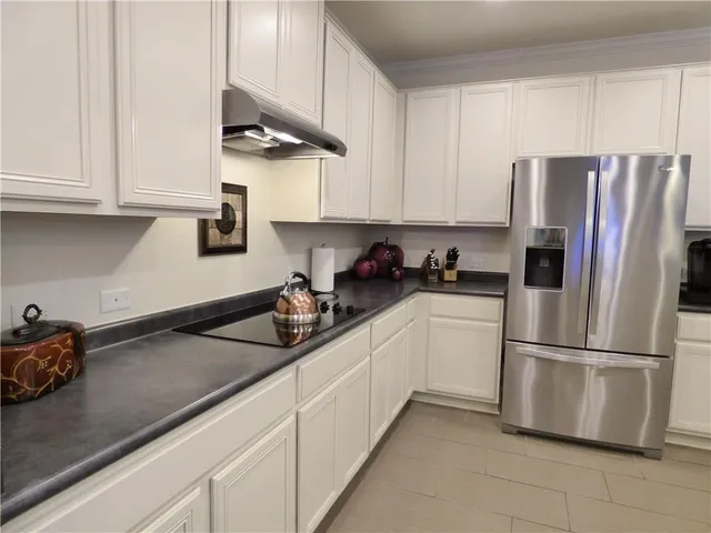 a kitchen with stainless steel appliances granite countertop a refrigerator sink and cabinets
