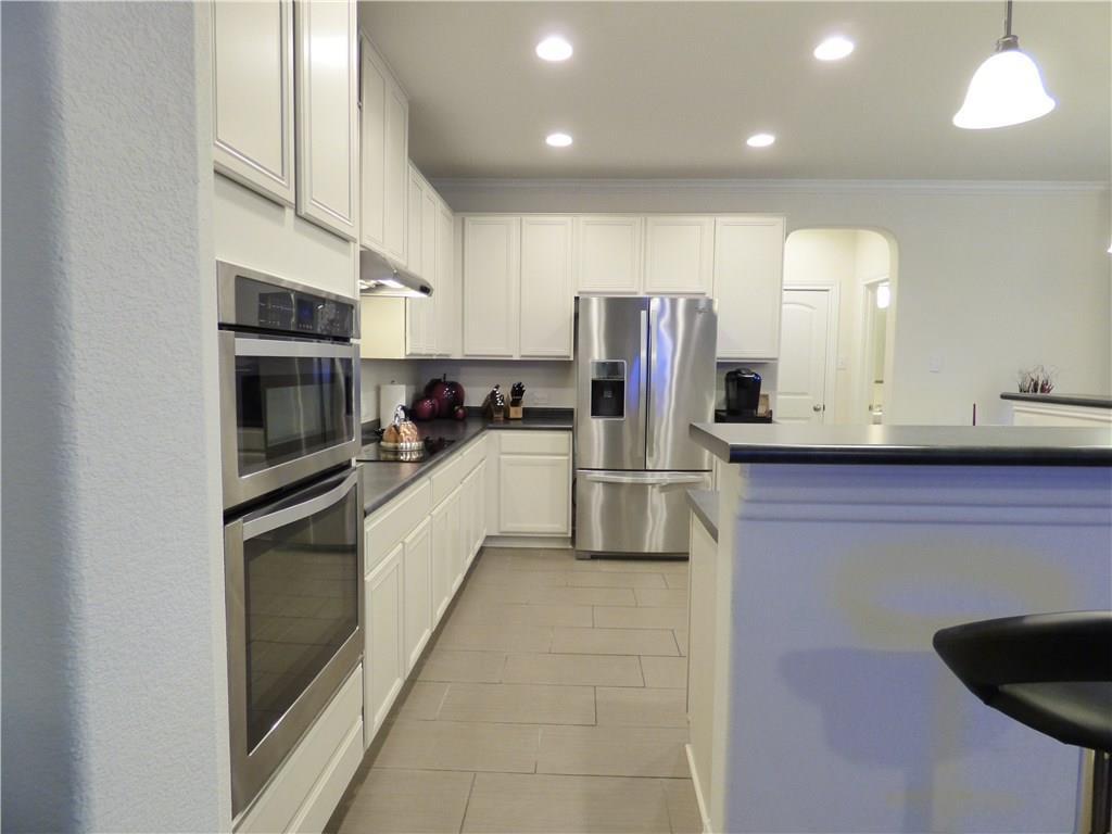 1216 Yellow Iris Road Leander, TX 78641 - Photo 18 of 33 a kitchen with stainless steel appliances granite countertop a refrigerator and a stove