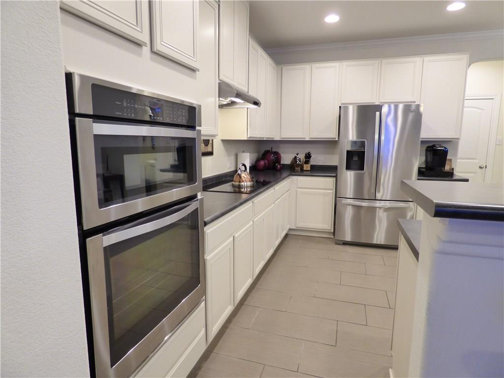 1216 Yellow Iris Road Leander, TX 78641 - Photo 19 of 33 a kitchen with a refrigerator stove and microwave
