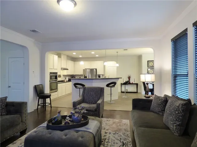 a living room with furniture and a view of kitchen