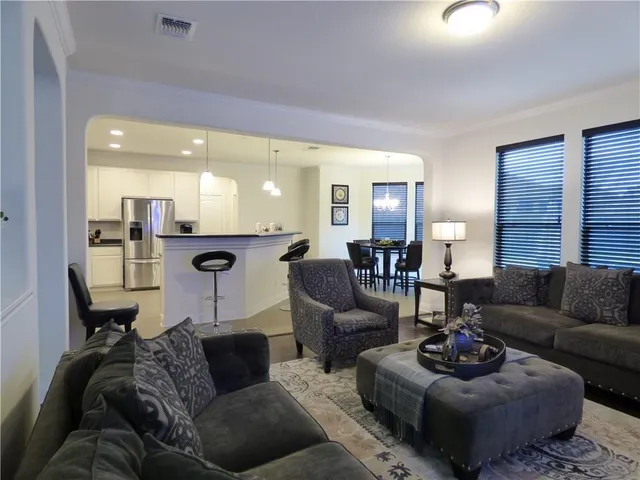 a living room with furniture and a view of kitchen