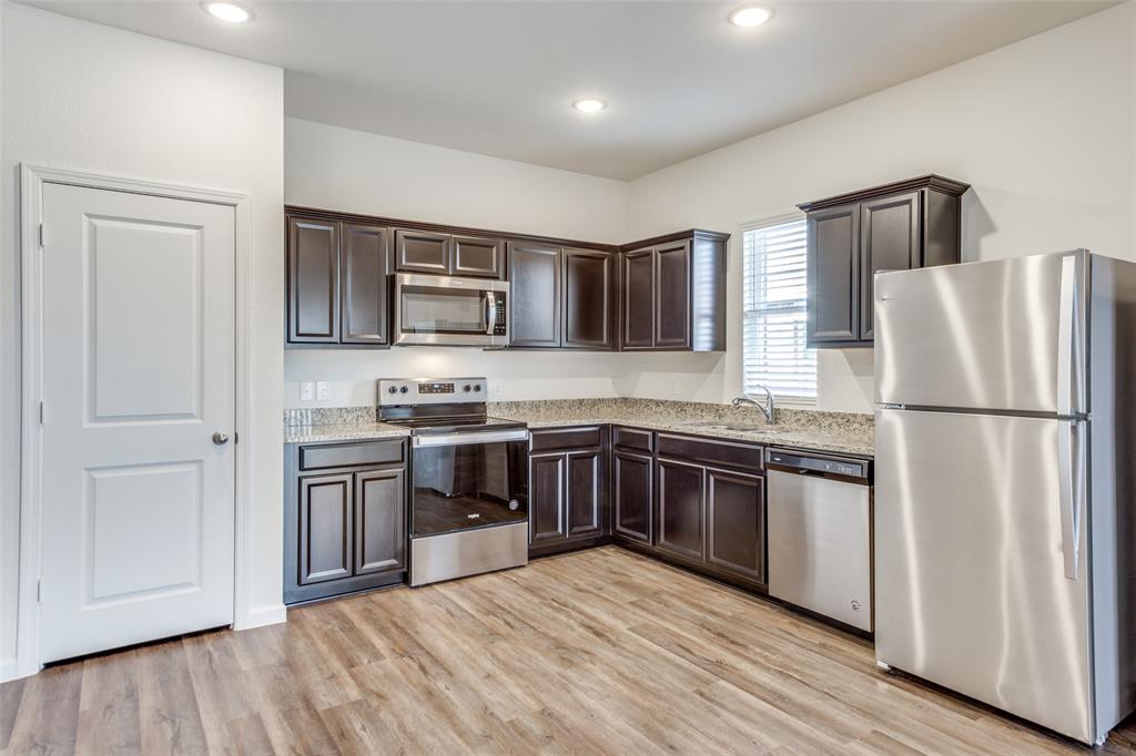 1819 Wolf Run Anna, TX 75409 - Photo 5 of 11 Kitchen featuring dark wood cabinetry, granite countertops, stainless steel appliances, wood-finish flooring, and recessed lighting