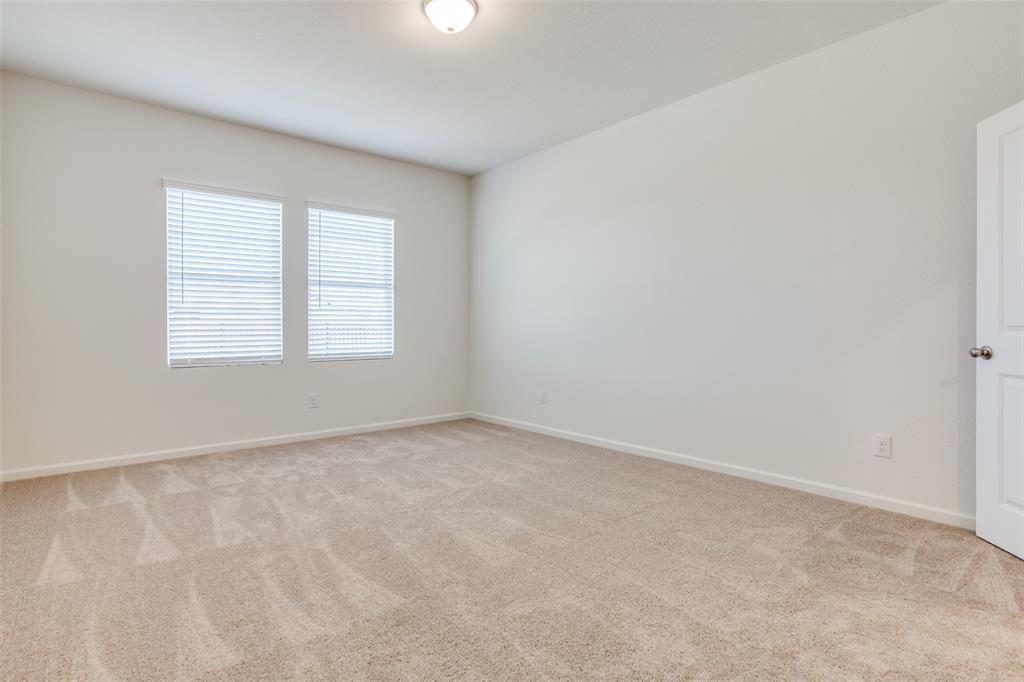 1819 Wolf Run Anna, TX 75409 - Photo 7 of 11 Carpeted interior space featuring two windows with blinds, neutral wall paint, and a white interior door
