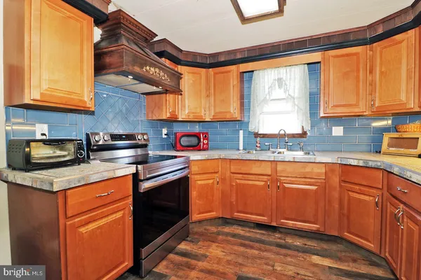 a kitchen with stainless steel appliances granite countertop a sink a stove and a refrigerator