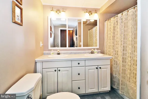 a bathroom with a granite countertop toilet sink and a mirror