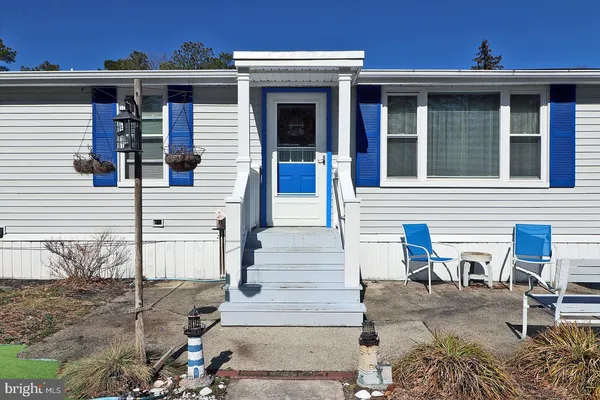 front view of a house with a chairs and table in the patio
