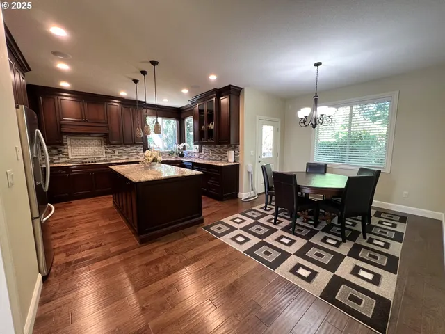 a kitchen with kitchen island granite countertop stainless steel appliances a sink stove and refrigerator