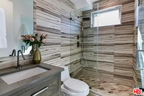 a bathroom with a toilet a sink and mirror