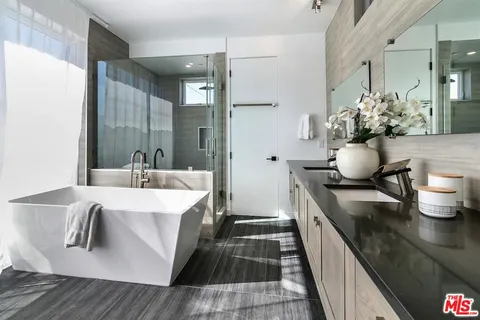 a spacious bathroom with a double vanity sink a mirror and a shower