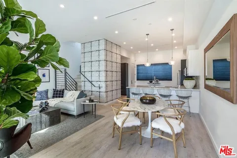 a dining room with furniture and a potted plant