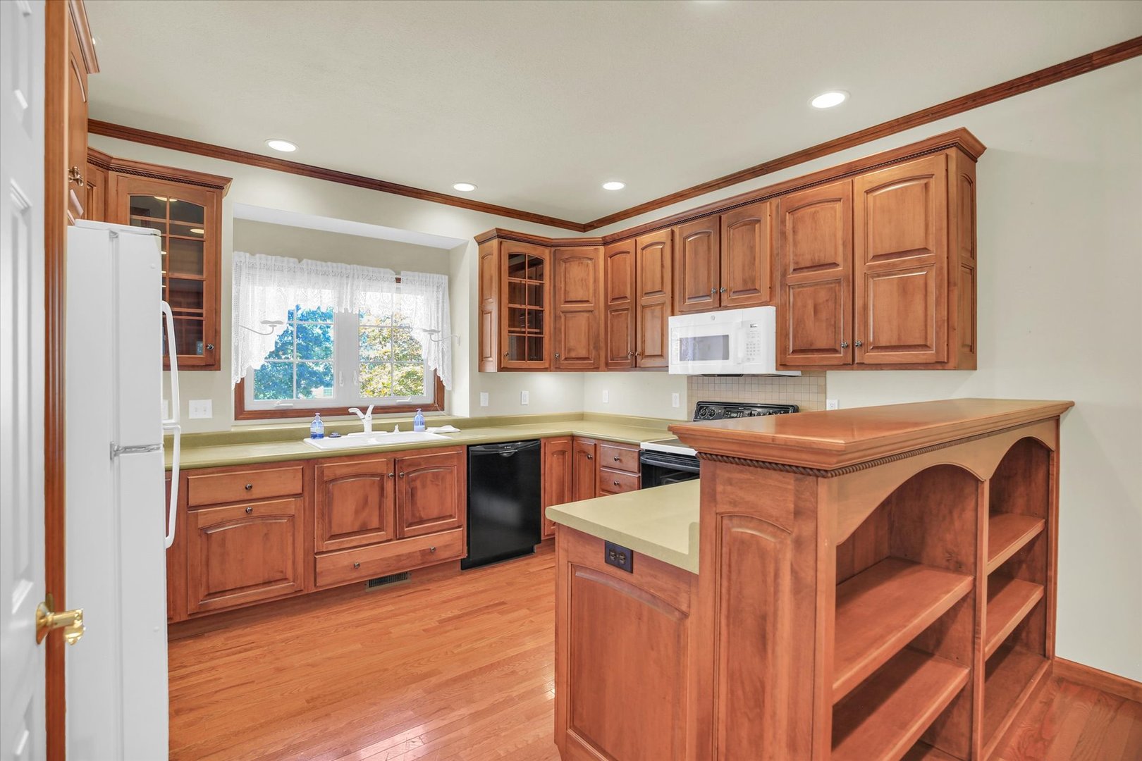 2424 Prairie Ridge Place Champaign, IL 61822 - Photo 11 of 48 a kitchen with stainless steel appliances granite countertop wooden cabinets a stove top oven a sink and dishwasher with wooden floor