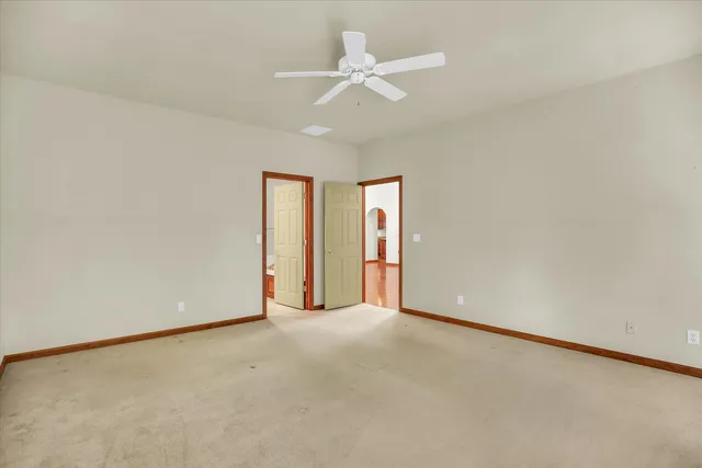 an empty room with a ceiling fan and a window