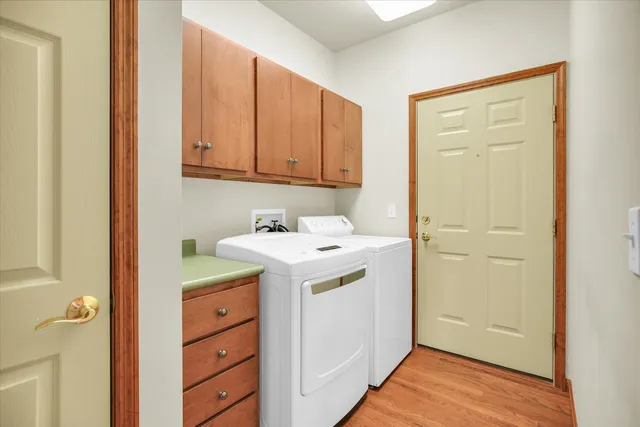 a utility room with cabinets washer and dryer