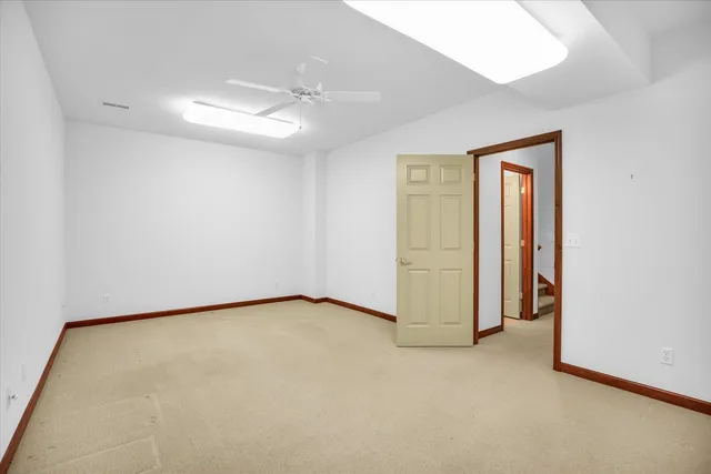 an empty room with a ceiling fan and closet area