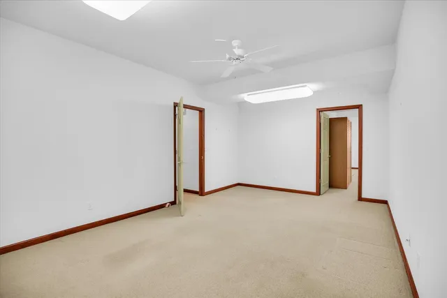 an empty room with closet and a chandelier fan