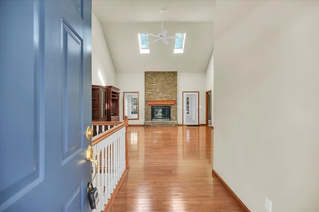 a view of a livingroom with wooden floor and a fireplace