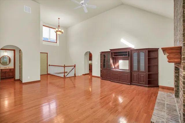 a view of an empty room with window and wooden floor