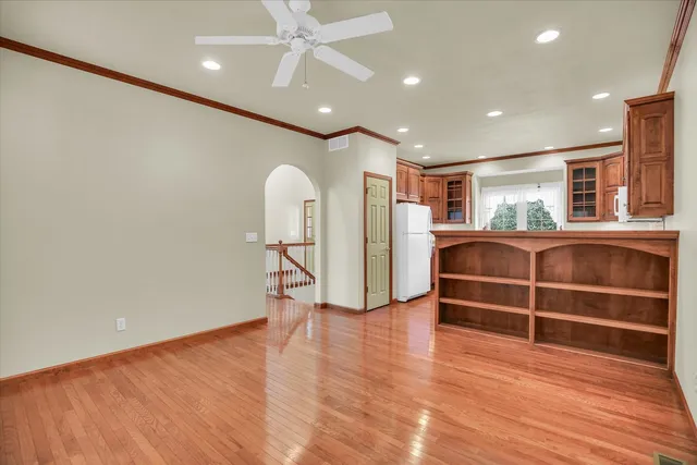 a view of an empty room with wooden floor and windows