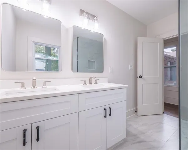 a bathroom with double sink and a mirror