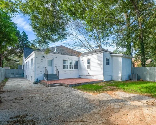 a view of a house with a yard and large tree