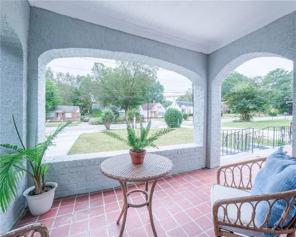 a living room with fireplace furniture and a potted plant