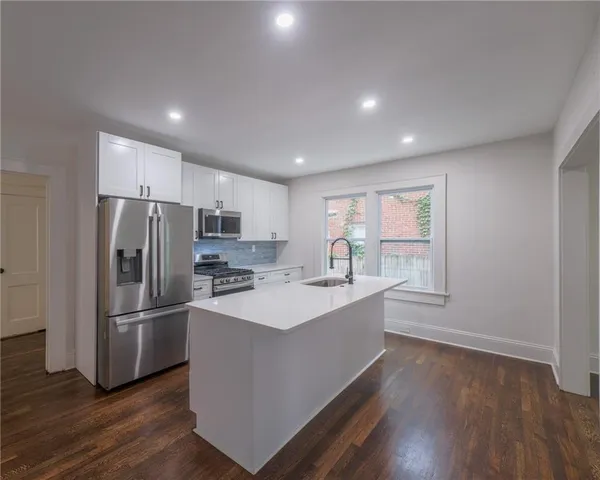 a kitchen with refrigerator cabinets and wooden floor