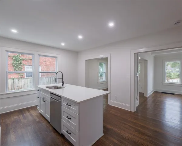 a view of a kitchen counter space a sink and wooden floor
