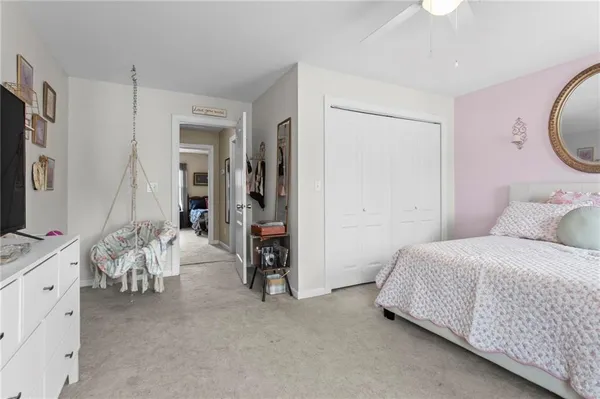 a bedroom with bed and a flat tv screen on dresser