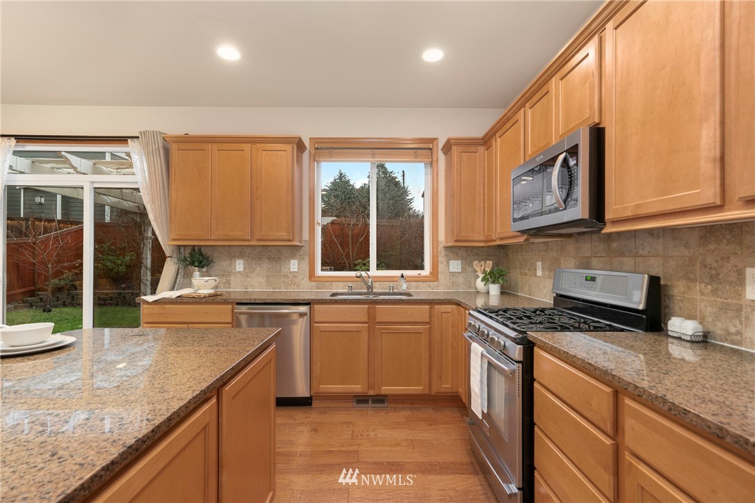 3616 Mill Place South Renton, WA 98055 - Photo 8 of 25 a kitchen with stainless steel appliances granite countertop a stove a sink and a microwave