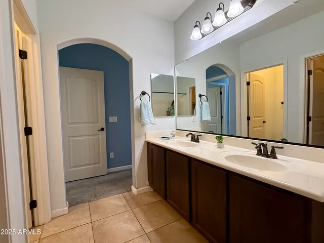 a spacious bathroom with a double vanity sink a mirror and a shower