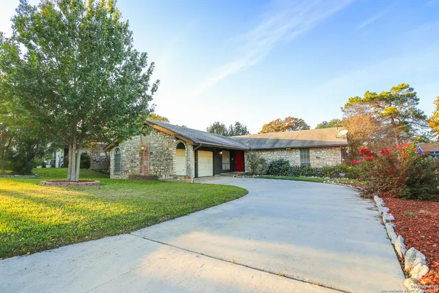 a front view of a house with a yard and many windows
