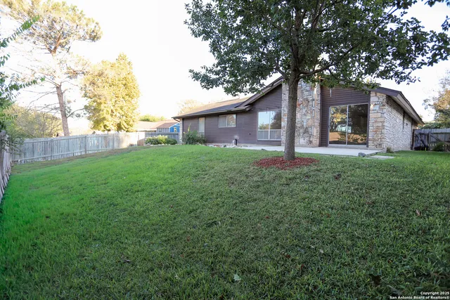 a house is sitting in middle od the grass