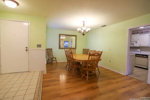 a view of a dining room with furniture and chandelier