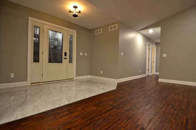 a view of a room with wooden floor and a window