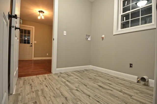 a view of empty room with wooden floor