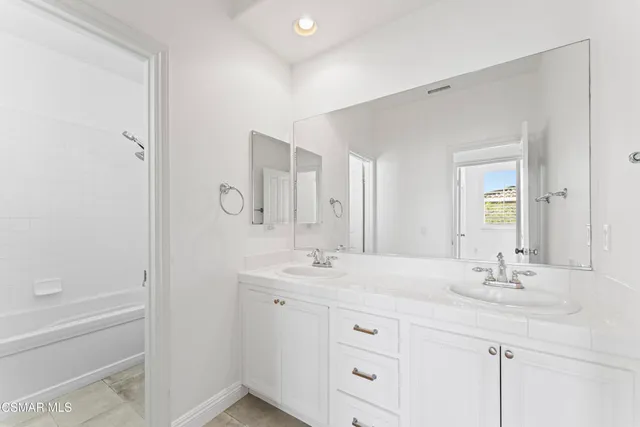 a bathroom with double sink and a mirror