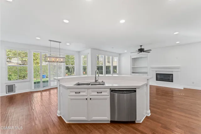 a kitchen with stainless steel appliances granite countertop hardwood floor sink stove and wooden floor