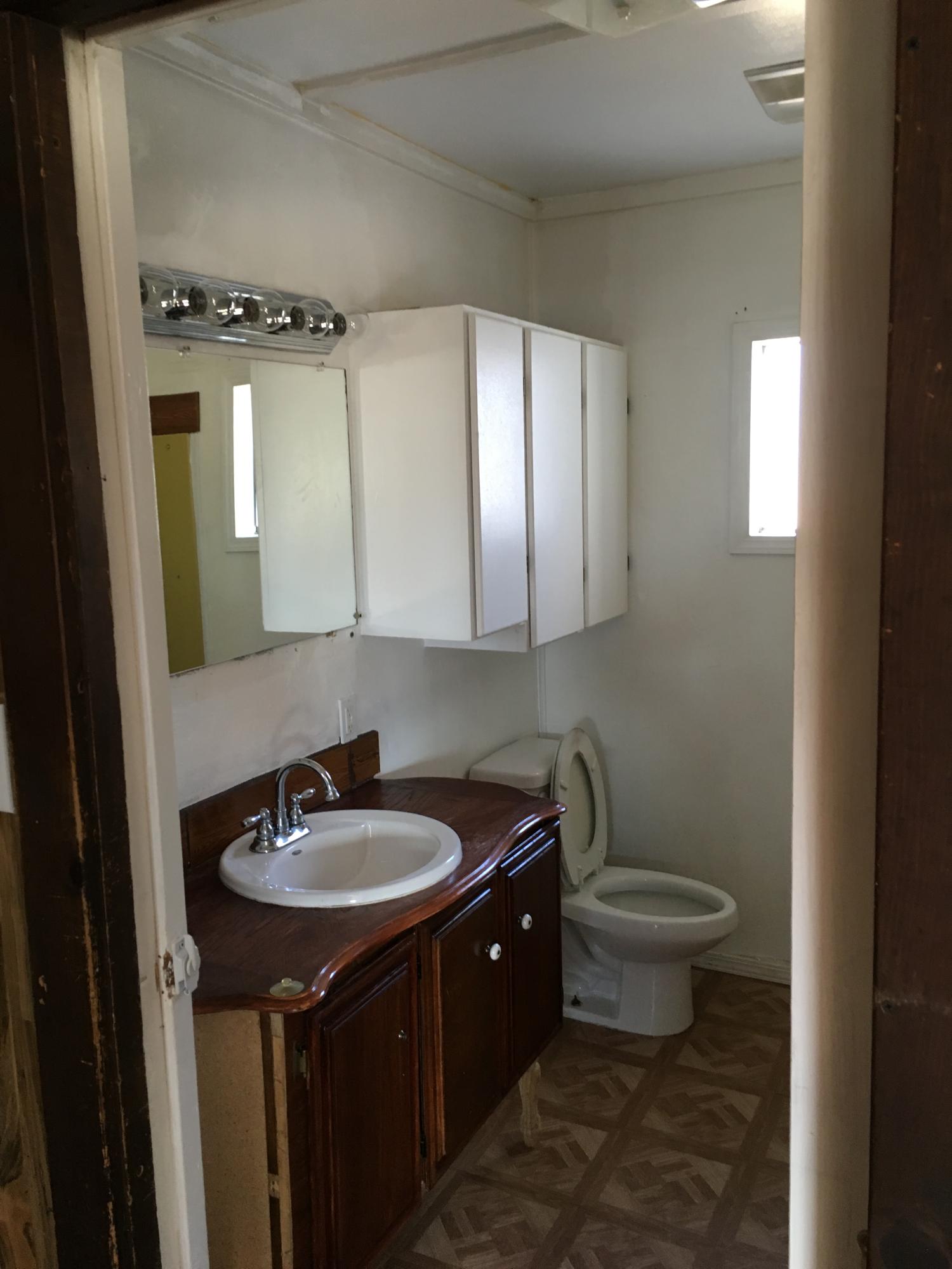 43254 52nd Street West Lancaster, CA 93536 - Photo 16 of 18 a bathroom with a sink toilet a mirror and vanity