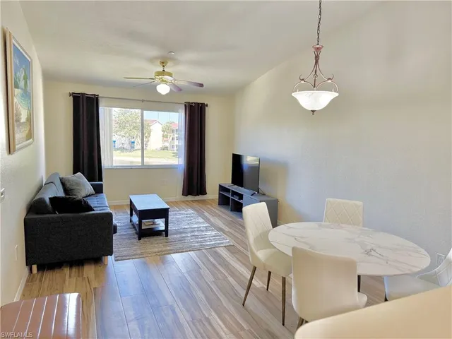 a living room with furniture a chandelier and a flat screen tv