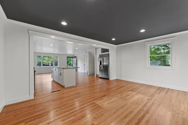 a view of empty room with wooden floor and windows