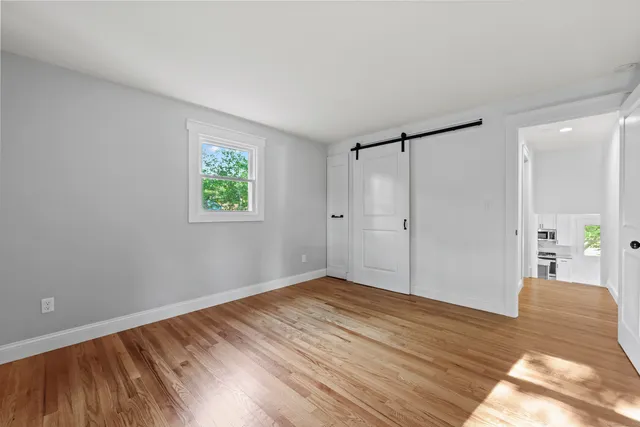 a view of empty room with wooden floor