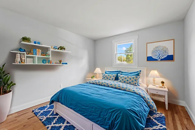 a bedroom with a bed and wooden floor