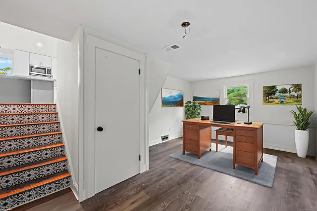 a view of a workspace with furniture and wooden floor