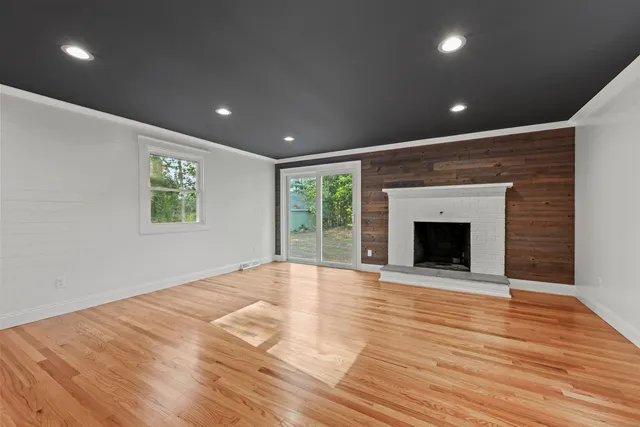 a view of empty room with wooden floor and fireplace