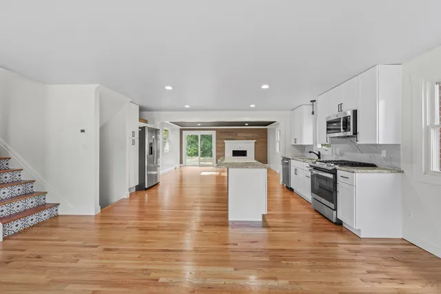a view of kitchen with microwave stove refrigerator and wooden floor