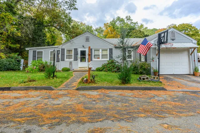 a front view of a house with a yard and potted plants